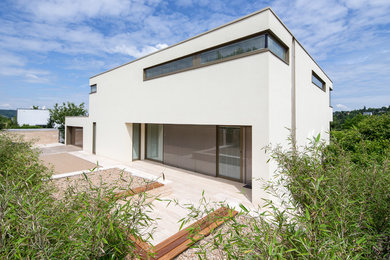 Großes, Zweistöckiges Modernes Haus mit Mix-Fassade, weißer Fassadenfarbe und Flachdach in Sonstige