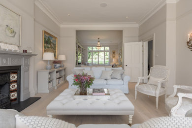 Photo of a large classic formal living room in Kent with grey walls, light hardwood flooring, a standard fireplace and no tv.