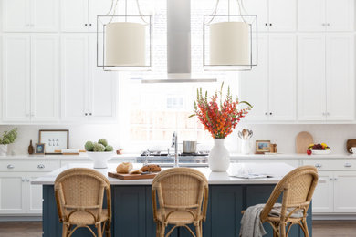 Open concept kitchen - huge traditional dark wood floor and brown floor open concept kitchen idea in Dallas with an undermount sink, shaker cabinets, white cabinets, quartz countertops, white backsplash, ceramic backsplash, stainless steel appliances, an island and white countertops