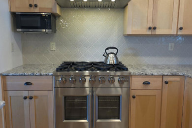 Inspiration for a craftsman laminate floor kitchen remodel in Seattle with shaker cabinets, light wood cabinets, granite countertops and ceramic backsplash
