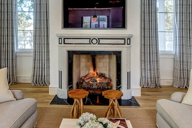 Inspiration for a mid-sized contemporary enclosed light wood floor and beige floor family room remodel in Dallas with white walls, a standard fireplace, a stone fireplace and a wall-mounted tv