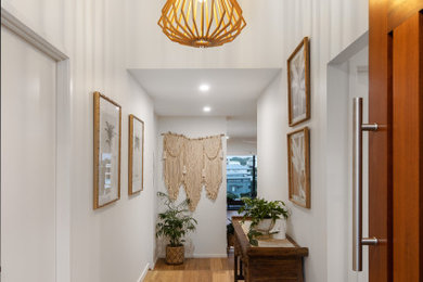 Entryway - mid-sized coastal medium tone wood floor entryway idea in Sunshine Coast with white walls and a medium wood front door