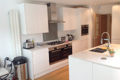 ロンドンにあるコンテンポラリースタイルのおしゃれなキッチン (白いキャビネット、シルバーの調理設備) の写真