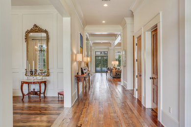 Example of a classic medium tone wood floor entryway design in New Orleans with white walls