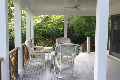 This is an example of a mid-sized traditional back porch design in New York with decking and a roof extension.