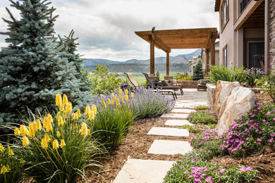 Mid-sized traditional backyard full sun xeriscape in Denver with natural stone pavers for summer.
