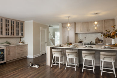 Inspiration for a mid-sized coastal galley vinyl floor and brown floor eat-in kitchen remodel in Other with an undermount sink, beaded inset cabinets, medium tone wood cabinets, quartz countertops, beige backsplash, quartz backsplash, paneled appliances, an island and beige countertops