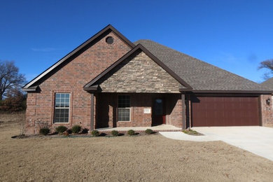 Inspiration for a mid-sized timeless red one-story brick gable roof remodel in Other