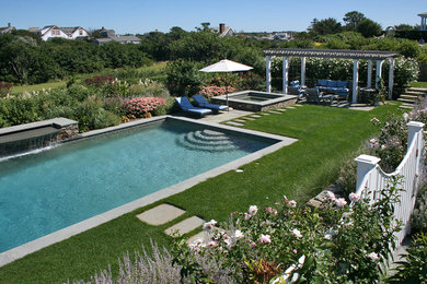 This is an example of a large transitional backyard rectangular lap pool in Boston with a hot tub.
