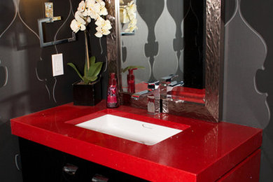 Inspiration for a mid-sized contemporary porcelain tile and brown floor powder room remodel in Edmonton with flat-panel cabinets, black cabinets, gray walls, an undermount sink and quartz countertops