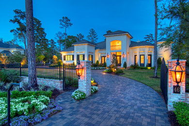 Large elegant white two-story stucco house exterior photo in Houston with a hip roof and a shingle roof