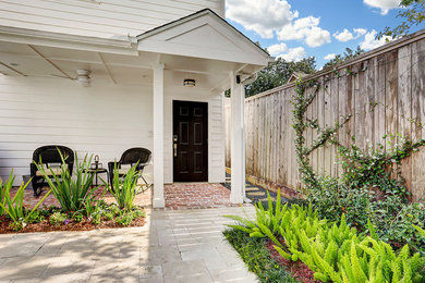Entryway - mid-sized transitional brick floor entryway idea in Houston with white walls and a black front door