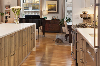 Inspiration for a mid-sized modern galley light wood floor and beige floor open concept kitchen remodel in Salt Lake City with an undermount sink, flat-panel cabinets, medium tone wood cabinets, quartz countertops, white backsplash, ceramic backsplash, stainless steel appliances and an island