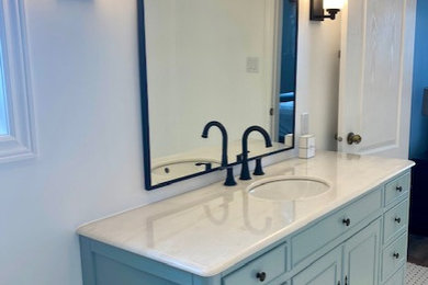 Mid-sized transitional master blue tile and ceramic tile mosaic tile floor, multicolored floor and single-sink bathroom photo in Ottawa with furniture-like cabinets, blue cabinets, a two-piece toilet, white walls, an integrated sink, marble countertops, white countertops and a freestanding vanity