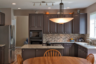 Mid-sized elegant l-shaped light wood floor eat-in kitchen photo in DC Metro with an undermount sink, raised-panel cabinets, granite countertops, white backsplash, glass tile backsplash, black appliances and an island