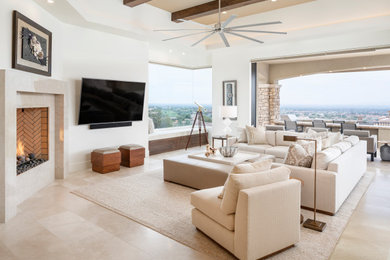 Photo of a transitional open concept living room in Phoenix with white walls, a standard fireplace, a tile fireplace surround, a wall-mounted tv and beige floor.