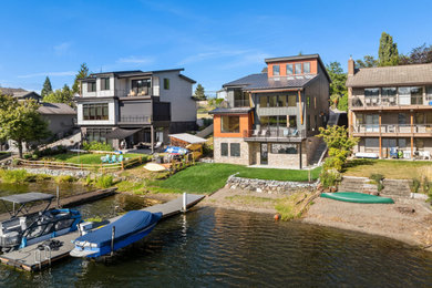 Example of a mid-sized minimalist gray three-story house exterior design in Seattle with a metal roof and a gray roof