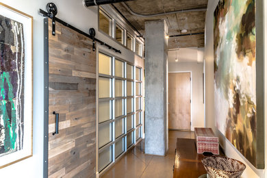 Inspiration for a small modern concrete floor and brown floor hallway remodel in Denver with beige walls