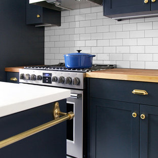 На фото: со средним бюджетом маленькие отдельные, параллельные кухни в классическом стиле с врезной раковиной, фасадами в стиле шейкер, синими фасадами, столешницей из дерева, белым фартуком, фартуком из плитки кабанчик, техникой из нержавеющей стали и мраморным полом без острова