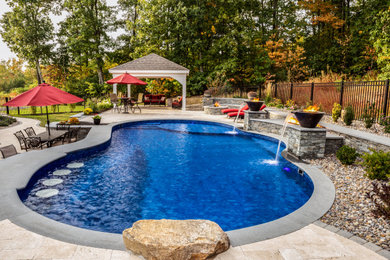 Modelo de piscina extra grande en patio trasero con adoquines de piedra natural