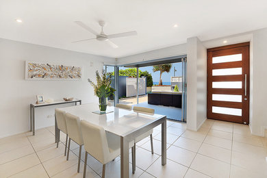Inspiration for an expansive beach style kitchen/dining combo in Gold Coast - Tweed with white walls and ceramic floors.