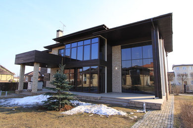 This is an example of a medium sized and beige scandinavian two floor detached house in Moscow with stone cladding, a hip roof and a shingle roof.