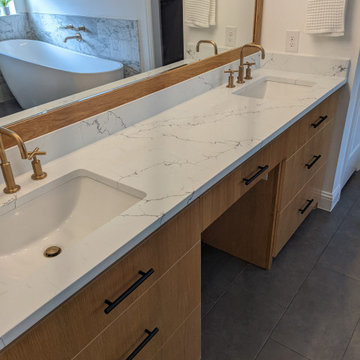 Modern primary bathroom with marble tile, curbless shower and custom vanity