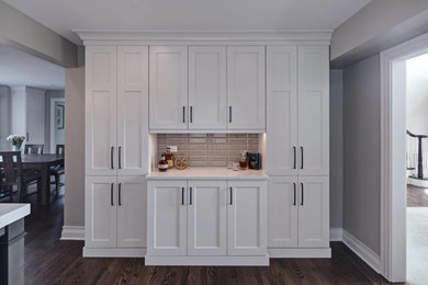 Example of a mid-sized transitional single-wall dry bar design in Chicago with recessed-panel cabinets, gray cabinets, quartz countertops, beige backsplash, ceramic backsplash and gray countertops