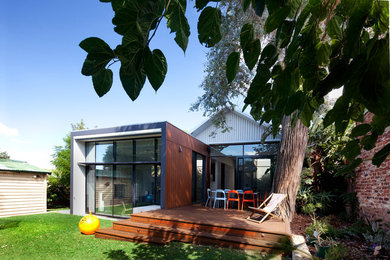 Photo of a mid-sized contemporary one-storey exterior in Perth with wood siding and a flat roof.