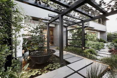 Inspiration for an industrial front yard partial sun garden in Melbourne with concrete pavers.
