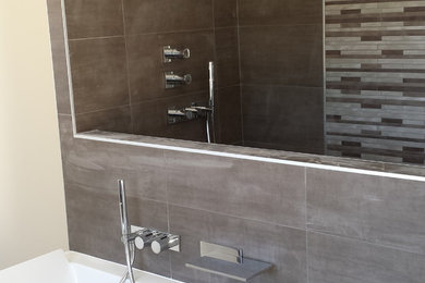 Design ideas for a contemporary bathroom in Lyon with an undermount tub, a shower/bathtub combo, brown tile, ceramic tile, brown walls and ceramic floors.