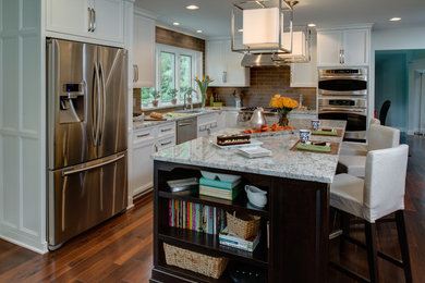 Example of a mid-sized transitional l-shaped dark wood floor eat-in kitchen design in Detroit with an undermount sink, recessed-panel cabinets, white cabinets, granite countertops, gray backsplash, stone tile backsplash, stainless steel appliances and an island