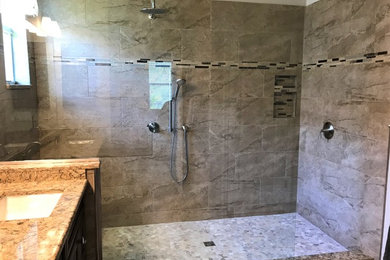 Example of a mid-sized trendy master beige tile open shower design in Tampa with recessed-panel cabinets, brown cabinets, an undermount sink and quartz countertops