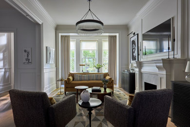 Example of a transitional light wood floor and beige floor living room design in Milwaukee with white walls, a standard fireplace, a stone fireplace and a wall-mounted tv