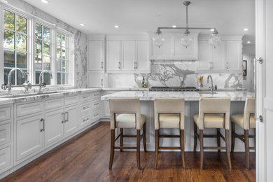 Example of a large transitional l-shaped eat-in kitchen design in Dallas with white cabinets, paneled appliances and an island