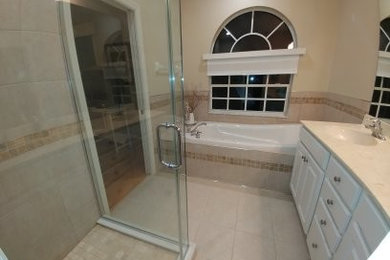 Contemporary bathroom in Jacksonville with beige cabinets and double sinks.