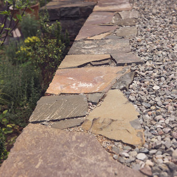 Stacked basalt retaining wall with gravel border