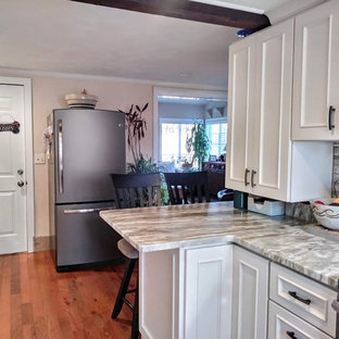 Small modern kitchen pantry in Providence with granite benchtops, grey splashback, stone tile splashback, stainless steel appliances, white benchtop, recessed-panel cabinets, white cabinets, laminate floors, no island and brown floor.