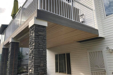 Deck - mid-sized contemporary backyard second story metal railing deck idea in Edmonton