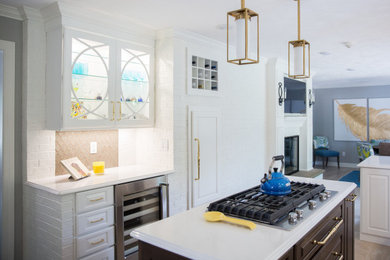 Inspiration for a timeless kitchen remodel in Other with raised-panel cabinets, white cabinets, quartz countertops, glass sheet backsplash, stainless steel appliances, an island and white countertops