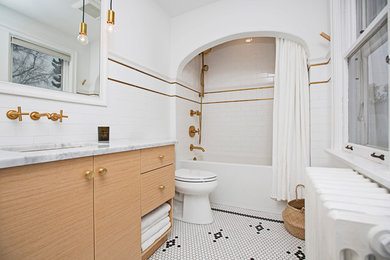 This is an example of a mid-sized transitional master bathroom in Edmonton with flat-panel cabinets, light wood cabinets, an alcove tub, a shower/bathtub combo, a one-piece toilet, white tile, ceramic tile, white walls, mosaic tile floors, an undermount sink, marble benchtops, white floor and a shower curtain.
