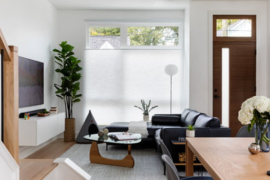 Example of a mid-sized trendy light wood floor and beige floor living room design in Raleigh with a wall-mounted tv