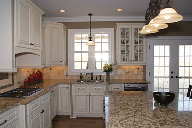 Inspiration for a mid-sized timeless u-shaped eat-in kitchen remodel in Other with an undermount sink, recessed-panel cabinets, white cabinets, granite countertops, beige backsplash, stone tile backsplash, stainless steel appliances and an island