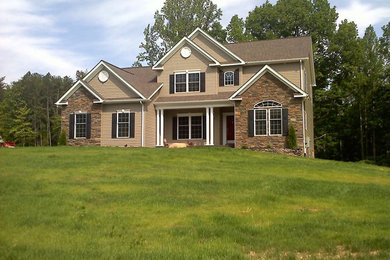 Example of a mid-sized classic beige two-story exterior home design in Other