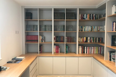 This is an example of a large contemporary study in Hertfordshire with grey walls and a built-in desk.