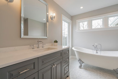 Inspiration for a large master marble floor, white floor and single-sink bathroom remodel in Philadelphia with raised-panel cabinets, gray cabinets, a two-piece toilet, gray walls, an undermount sink, quartz countertops, a hinged shower door, white countertops and a freestanding vanity