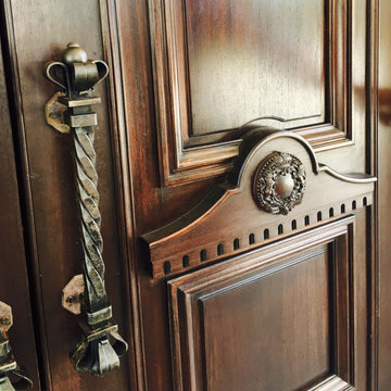We are designers and builders of carved wood doors with wrought metal appliqués.
