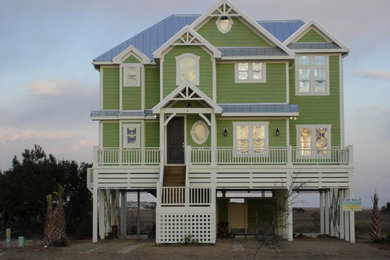 Large beach style green two-story concrete fiberboard house exterior photo in Other with a hip roof and a metal roof