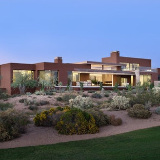 Выдающиеся фото от архитекторов и дизайнеров интерьера: большой, двухэтажный фасад частного дома розового цвета в современном стиле с облицовкой из цементной штукатурки, плоской крышей и зеленой крышей