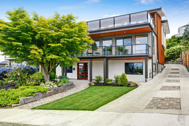 Example of a large minimalist multicolored three-story mixed siding house exterior design in Seattle with a shed roof and a mixed material roof